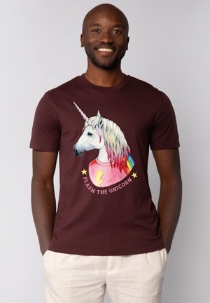Bordeauxrood t-shirt met een afbeelding van een eenhoorn met een regenboog manen, een bliksemschicht en de tekst "FLASH THE UNICORN" in een cirkelontwerp.