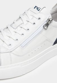Baskets en cuir blanc avec une finition texturée, dotées d'une fermeture éclair sur le côté, de détails perforés et d'une semelle en caoutchouc. Accentuées par des éléments navy.