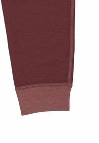 Bordeauxfarvede sweatpants med tætsiddende manchet, blød tekstur og kontrasterende lys bordeauxkant. Sømdetalje langs siden.