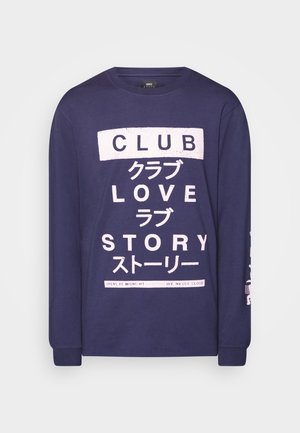 Marineblaues Langarm-T-Shirt aus weichem Baumwollstoff; mit weißem Text in verschiedenen Schriftarten und Sprachen, einschließlich "CLUB" und "LIEBESGESCHICHTE."