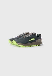 Un paio di scarpe da corsa impermeabili grigio scuro e verde neon con lacci, angolate a destra su uno sfondo bianco.