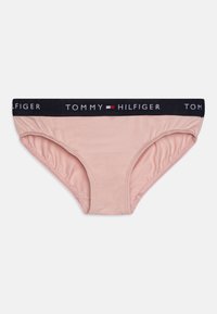Slip in cotone rosa chiaro con elastico blu navy, caratterizzato dal logo "TOMMY HILFIGER" in bianco e dettagli rossi. Design classico del slip.