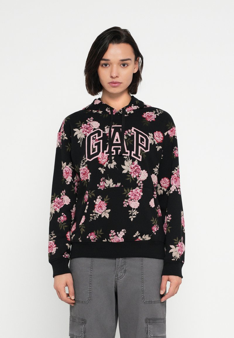 Czarna bluza z kapturem w kwiatowy wzór, z widocznym logo "GAP" w wyrazistych różowych literach. Zaprojektowana z kapturem na sznurek i ściągaczami na mankietach.