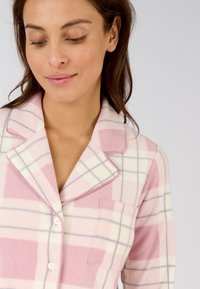 Maglia da pigiama a quadri rosa e bianchi realizzata in tessuto morbido, con colletto a punta, chiusura con bottoni e una singola tasca sul petto.