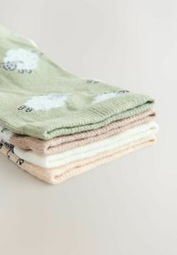 Vijf paren katoenen sokken, met een groen paar met schapenprint en effen pastelt kleuren: beige, wit en lichtroze, netjes gestapeld.
