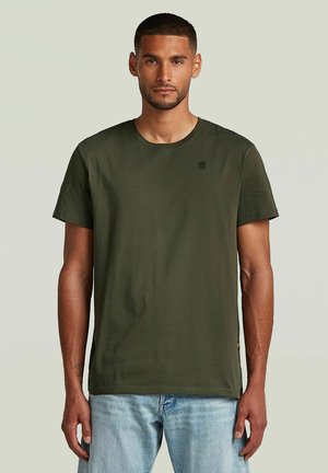 Olive green cotton t-shirt with a crew neck, short sleeves, and a small logo on the chest. Paired with light blue denim jeans.