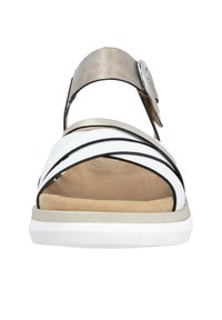 White and black cross-strap sandal with a metallic beige ankle strap, cushioned footbed, and textured white rubber sole.
