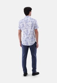 Kurzärmliges Hemd mit weißem Hintergrund und blauem Blumenmuster, kombiniert mit nachtblauen Hosen. Verfügt über einen spitzen Kragen und eine lockere Passform.
