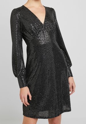 Schwarzes Kleid mit tiefem V-Ausschnitt, langen puffärmeln und schimmerndem silbernem Punktmuster auf strukturiertem Stoff.