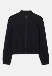 Musta bomber-takki, jossa on raglan-hihat, ribboitetut hihansuut ja helmassa sekä vetoketjukiinnitys ja sivutaskut. Valmistettu pehmoisesta ja joustavasta materiaalista.