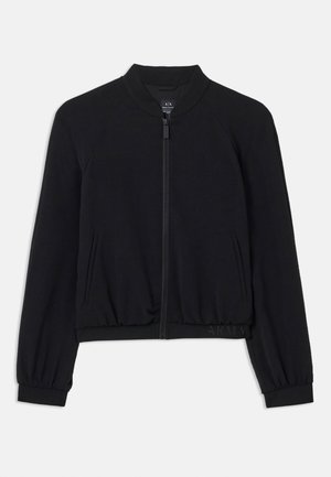 Chaqueta bomber negra con mangas raglán, puños y dobladillo acanalados, cierre de cremallera y bolsillos laterales. Fabricada con material suave y elástico.