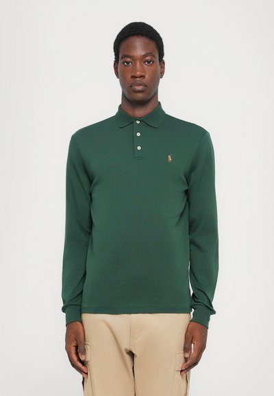 Camisa polo de manga larga en algodón verde oscuro, con cuello de camisa, tapeta de tres botones y un pequeño logo bordado en el pecho.