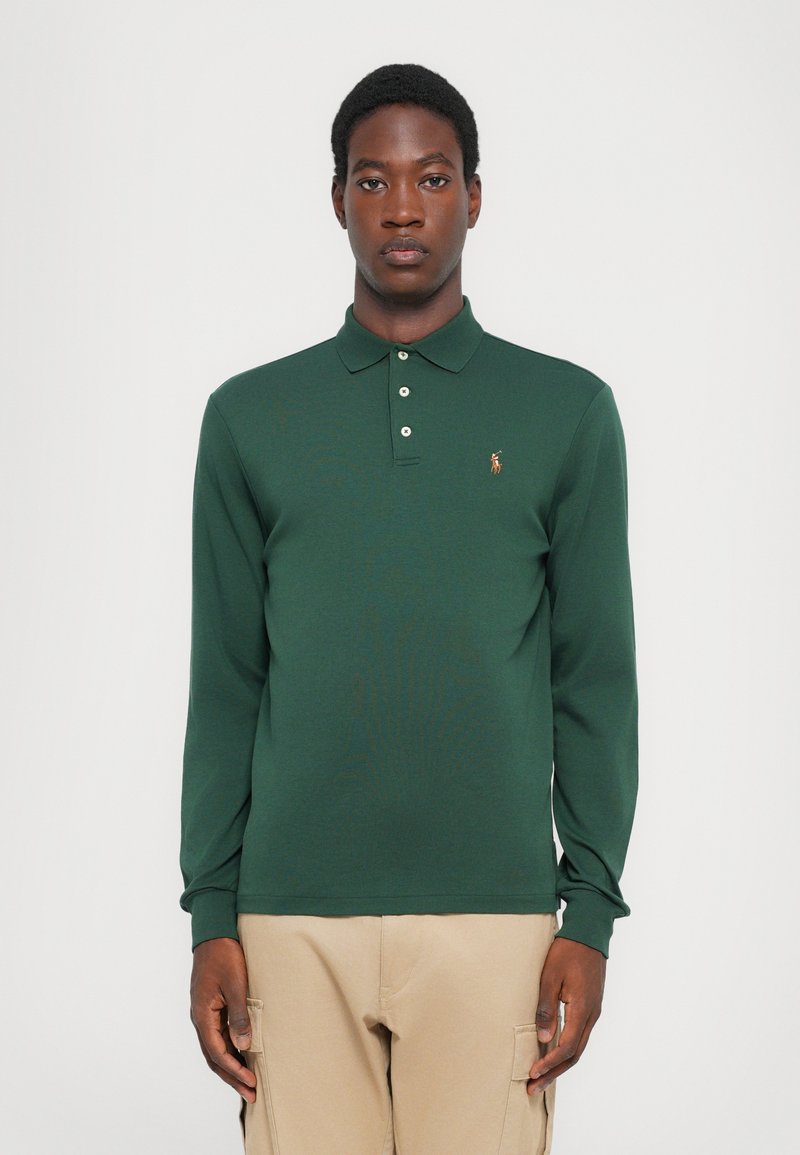 Camisa polo de manga larga en algodón verde oscuro, con cuello de camisa, tapeta de tres botones y un pequeño logo bordado en el pecho.