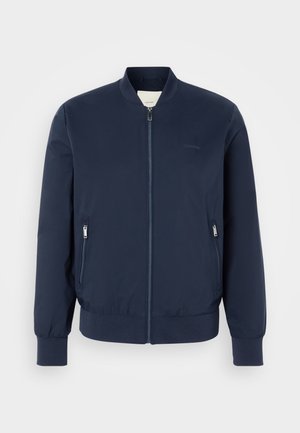 Navy bomber jacket made of lightweight fabric, featuring a front zipper, two zippered side pockets, and ribbed cuffs and hem.