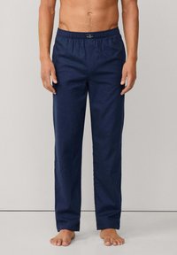 Pantalones de algodón azul marino con cintura elástica, corte relajado y sin patrones ni detalles metálicos visibles.