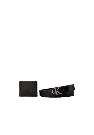 Mustast nahast rahakott ja mustast nahast vöö, millel on hõbedane "cK" logo pandla, asetatud kõrvuti valgel taustal.