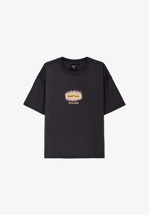 Overwymiarowa czarna bawełniana koszulka z okrągłym dekoltem. Posiada centralny grafikę w kształcie płomienia z tekstem w kolorze różowym, żółtym i czarnym.