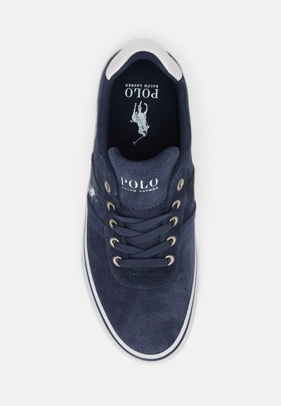 Mørkeblå suedesneakers med hvide snørehuller og en hvid gummisål. Har et hævet logo og en simpel tunge-design.