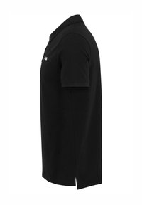 Svart polo-skorta i bomull med korta ärmar, krage, sidofickor och en liten logodetalj på bröstet.