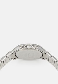 Montre en acier inoxydable argenté avec un boîtier rond, deux boutons-poussoirs et une couronne texturée. Le bracelet présente des maillons avec une finition polie.
