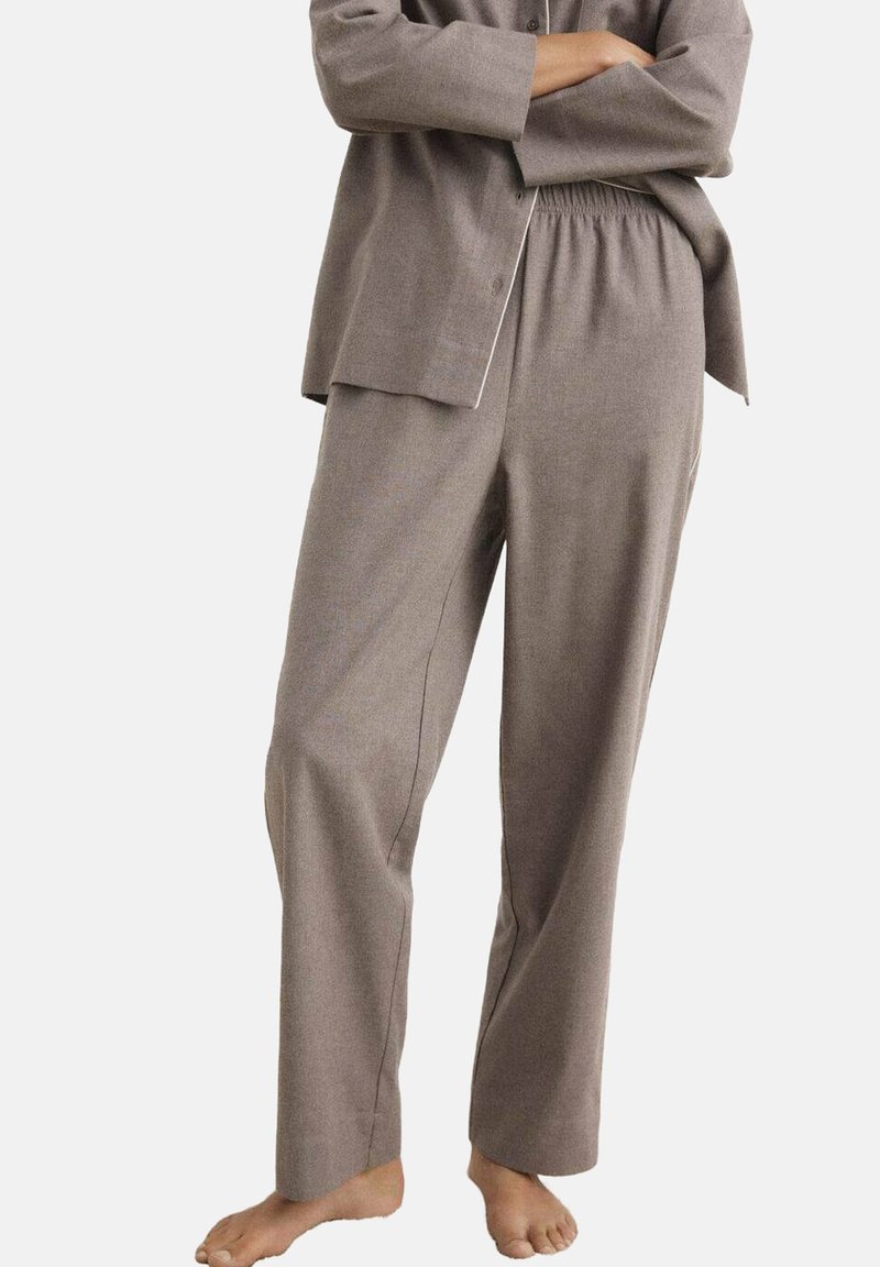 Pantalones sueltos de color marrón claro con cintura elástica y bolsillos laterales, hechos de una tela suave y texturizada.