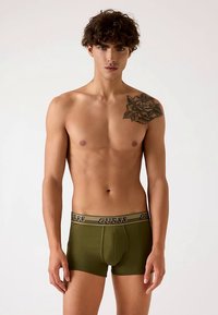 Olivgrüne Herren-Boxershorts mit enger Passform, ausgestattet mit einem logoverzierten Bund und einer vorderen Tasche zur Unterstützung. Glatte Textur und elastisches Band.