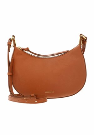 Sac bandoulière en cuir brun en forme de croissant avec ferrures dorées et sangle ajustable, marqué du logo "Coccinelle" en petites lettres dorées.