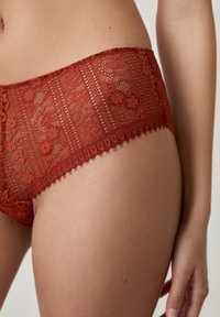 Mutande hipster in pizzo rosso con motivi floreali, dettagli intricati, bordo scallop e tessuto trasparente.