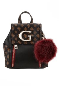 Sac à dos marron à motifs avec une base en cuir noir, des ferrures argentées, un logo bien visible et un pompon en fourrure bordeaux attaché.