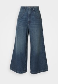 Vaqueros de pierna ancha de cintura alta, hechos de mezclilla. Color azul oscuro con efecto desgastado, con bolsillos frontales y cierre de botón.