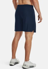 Pantalones cortos deportivos de color navy con una cinturilla elástica, que presentan aberturas laterales para mayor movilidad. Tejido ligero, sin patrones o elementos metálicos visibles.