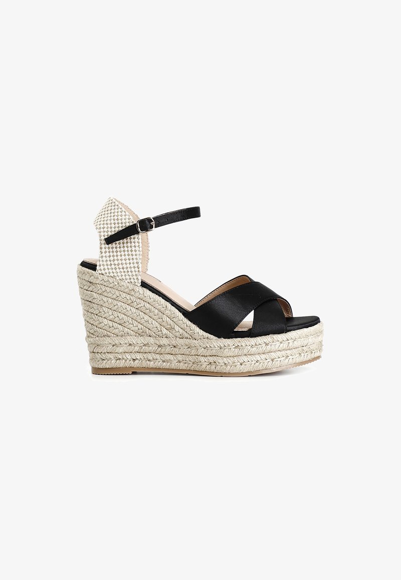 Czarne skórzane sandały na koturnach z krzyżującymi się paskami, z plecioną, w stylu espadryli, środkową podeszwą oraz wzorzystym materiałem z tyłu. Z regulowanym paskiem wokół kostki.
