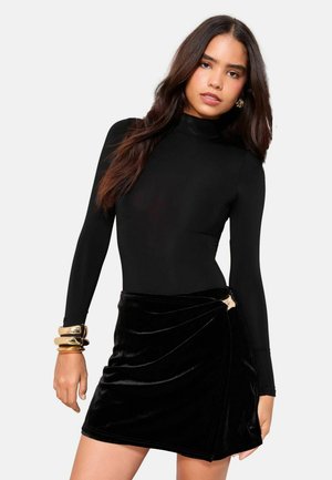 Bodysuit noir à manches longues associé à une mini jupe en velours noir avec un design enveloppant et des accessoires en or. Texture lisse partout.