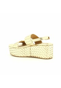 Sandaletta wedge in oro metallizzato con texture intrecciata, punta aperta, doppi cinturini e suola piatta larga. Rivestimento interno morbido e fibbia regolabile.