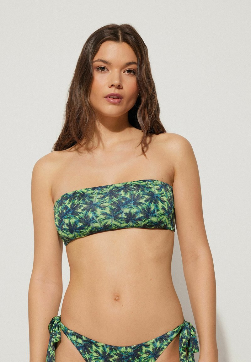 Bandeau bikiny top a zavazovací spodní díl s živým zeleno-modrým vzorem palmových listů, vyrobené z plavkové tkaniny.
