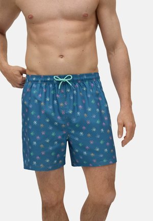 Shorts de baño de tela azul con cinturilla elástica y cordón de color menta; presentan pequeños patrones coloridos de pulpos por toda la prenda.