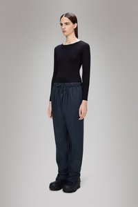 Čierne dlhé rukávy, skombinované s tmavomodrými elastickými nohavicami v páse. Model má na sebe čierne masívne boty. Jednoduchý, minimalistický dizajn.