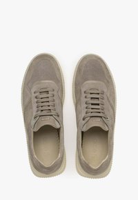 Grijze suède sneakers met geperforeerde accenten, ronde teenontwerp, platte veters en een contrasterende rubberen zool. Zacht, textuurmateriaal.