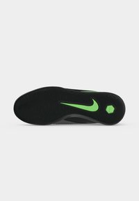 Μαύρη σόλα παπουτσιού με πράσινο λογότυπο Nike σε σχήμα φτερού και εξαγωνικό υφασμένο σχέδιο σε λευκό φόντο, που δείχνει το σχέδιο πέλματος.