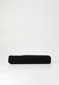 Zwarte rechthoekige kussen met een stof cover met textuur, met een subtiele glans en minimalistisch design, gezien vanuit de zijkant.