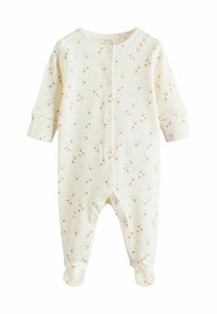 Combinaison en coton crème à manches longues pour bébé avec un motif d'étoiles en pêche et noir. Comprend des boutons-pression et un design avec pieds. Texture douce.