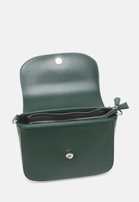 Grön läderhandväska med en slank design, lock med flip-top-stängning, inre zip-fack och silverfärgade detaljer.