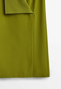 Oliivivärinen kangas, jossa on näkyvät r stitching-tiedot ja taitettu kulma yksinkertaisella valkoisella taustalla.