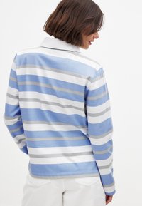 Prúžkovaná polo košeľa s dlhým rukávom v modrej, bielej a sivej farbe. Má golier a jemnú tkaninu s voľným strihom, viditeľným šitím a zakriveným lemom.