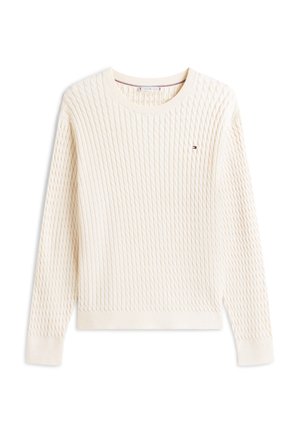 Μπεζ πουλόβερ με πλεκτό σχέδιο κοτσίδα, μακριά μανίκια, στρογγυλή λαιμόκοψη και μικρό ορθογώνιο κόκκινο, άσπρο και μπλε λογότυπο στο αριστερό στήθος.