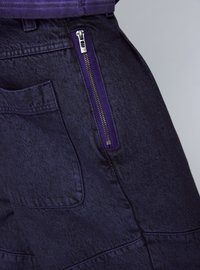Pantaloni cargo blu navy con cerniera viola a contrasto, tessuto testurizzato e dettaglio con tasca laterale, progettati per praticità e stile.