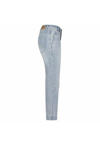 Jean en denim bleu clair avec une coupe slim, cinq poches, un ourlet roulé et une étiquette en cuir marron au niveau de la taille. Texture lisse.