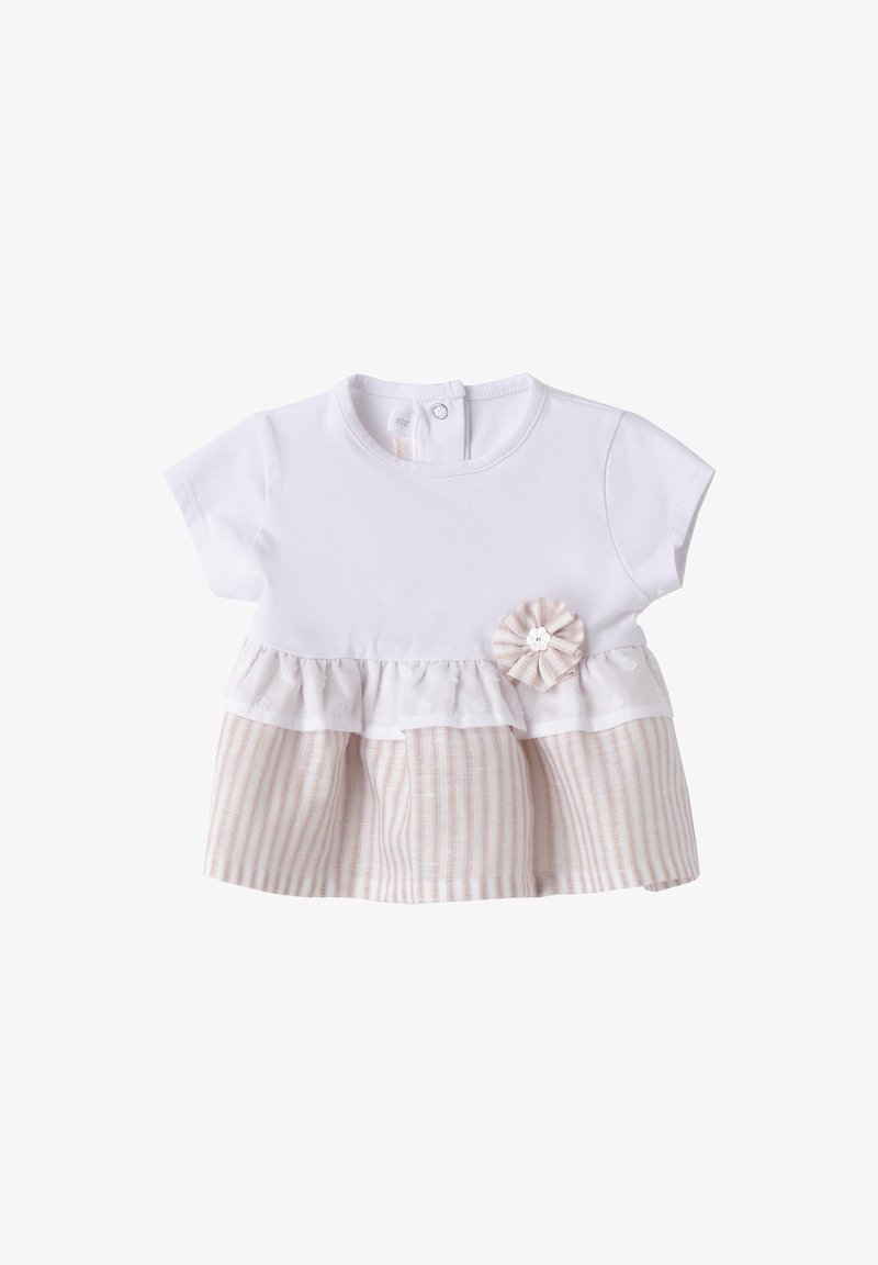 Top de algodón blanco con mangas cortas, que presenta un peplum de capas en tela a rayas de color beige y un acento decorativo de flor. Cierre de botón en la parte posterior.