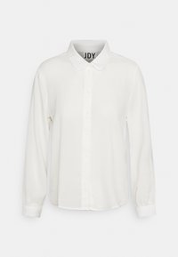 Vit långärmad blus med rund krage och framknäppning, presenterad mot en enfärgad bakgrund.