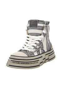 High-top sneakers made of mixed materials in gray, white, and black. Features thick, striped sole with text, eyelets, and white laces.